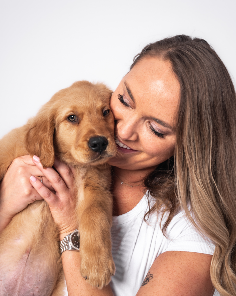 Golden retriever puppy being held close by owner during puppy portraits San Diego