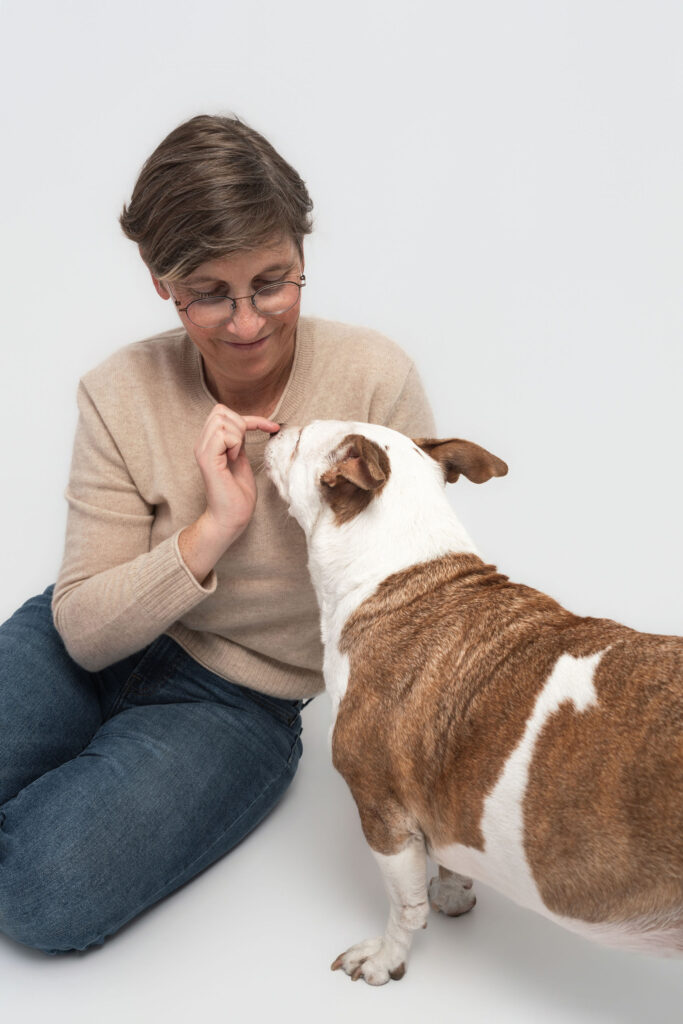 Dog mom and senior dog sitting together in studio portrait
