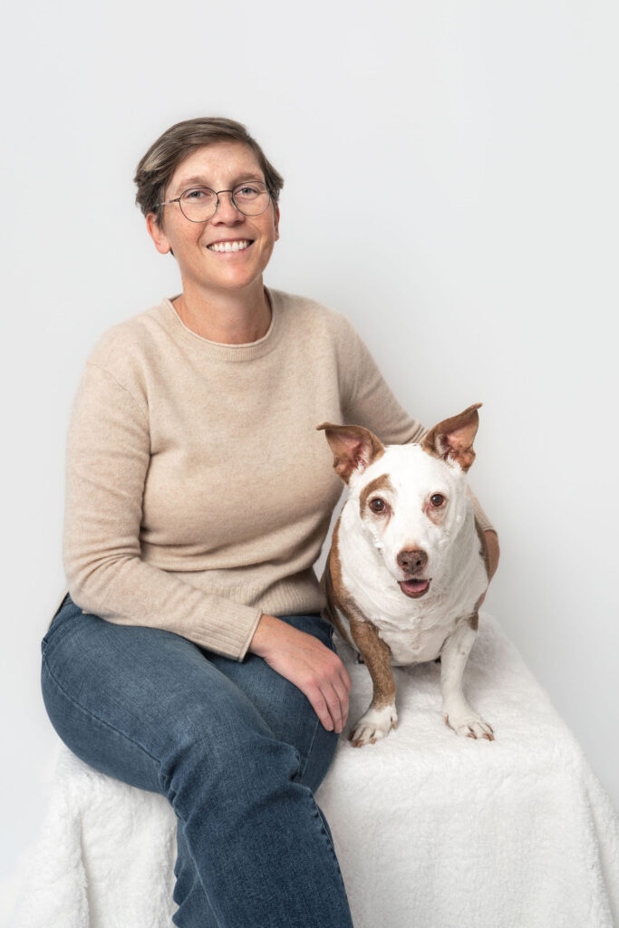 Dog mom gently holding her senior dog during a legacy session