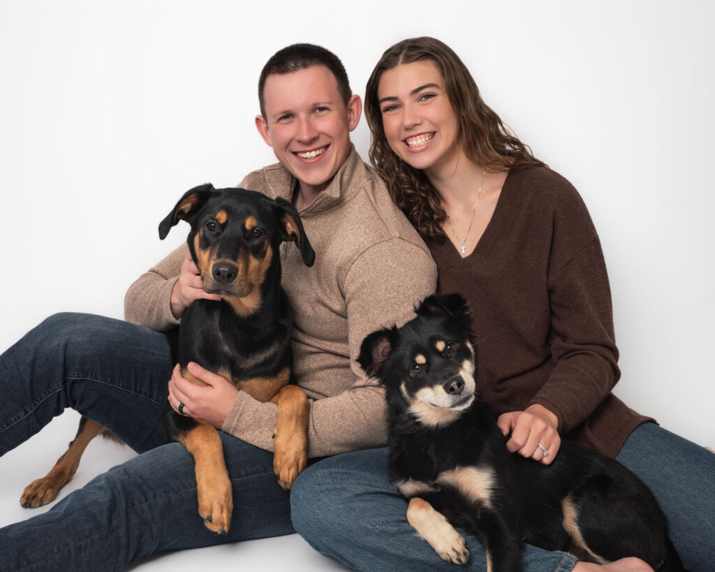 Couple posing with two dogs during family photos with dogs San Diego studio session